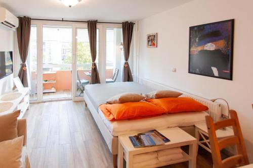 a bedroom with a bed with orange pillows and a table at Chic Cosy Quiet in Ljubljana Center in Ljubljana