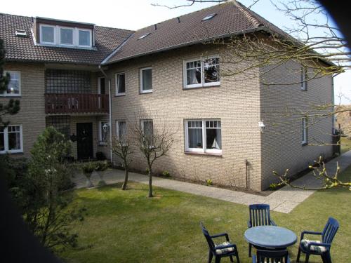 a house with a table and chairs in the yard at Strandhotel-Najade in Borkum