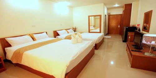 a hotel room with two beds and a television at Rafael Hotel and Mansion Bangkok - SHA Extra Plus Certified in Lat Krabang