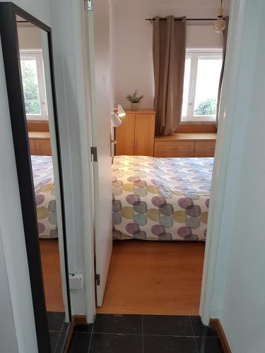a bedroom with a bed and a window and a mirror at Comfort City Hub - Metro Lisbon in Amadora