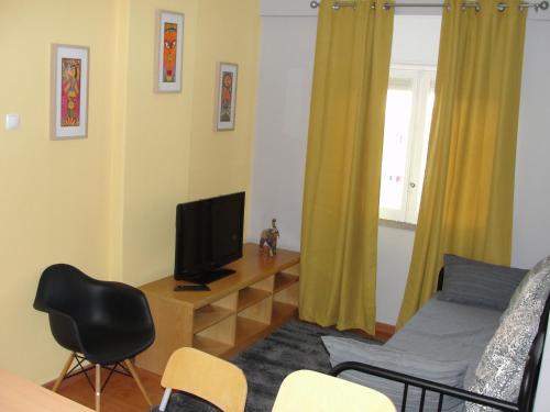 a living room with a bed and a television at Comfort City Hub - Metro Lisbon in Amadora