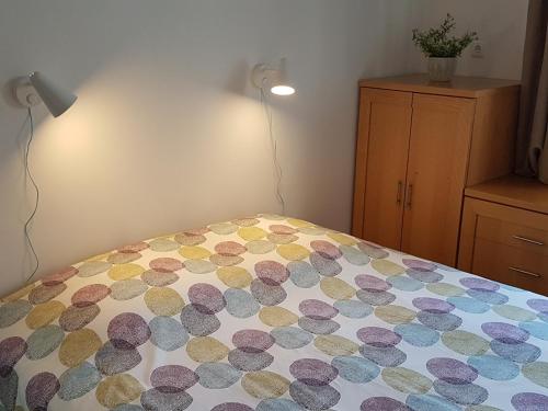 a bedroom with a bed with a polka dot blanket at Comfort City Hub - Metro Lisbon in Amadora