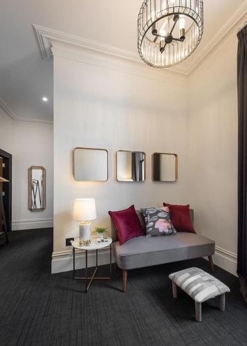 a living room with a couch and a chandelier at East Brunswick Hotel in Melbourne