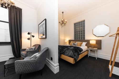 a bedroom with a bed and a chair and a mirror at East Brunswick Hotel in Melbourne