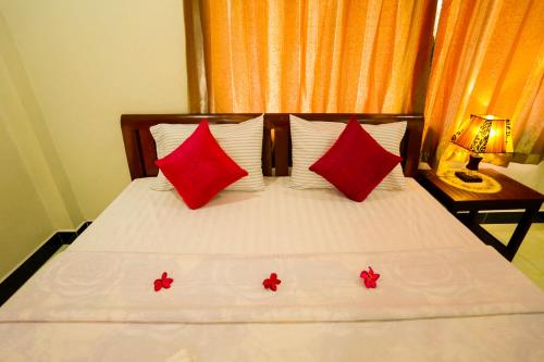a bed with two red pillows on top of it at Blue Diamond Hostel in Battambang