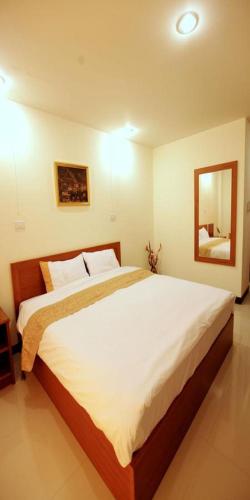a bedroom with a large white bed with a mirror at Rafael Hotel and Mansion Bangkok in Lat Krabang