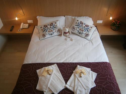 um urso de peluche sentado numa cama com toalhas em Le Badie Wine Resort em Rosazzo
