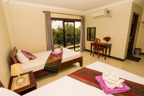 a living room with two beds and a balcony at Blue Diamond Hostel in Battambang