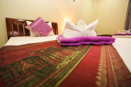 a bed with blankets and pillows on top of it at Blue Diamond Hostel in Battambang