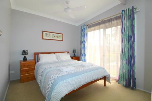 a bedroom with a bed and a window at Beachfront 6, 25 Willow Street in Crescent Head