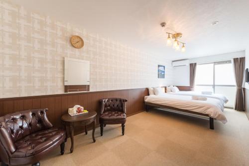 - une chambre avec un lit, une chaise et un réveil dans l'établissement Floral Green Maple House, à Kyoto