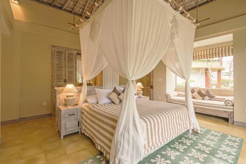 a hotel room with a bed and a canopy at Wapa di Ume Sidemen - CHSE Certified in Sidemen