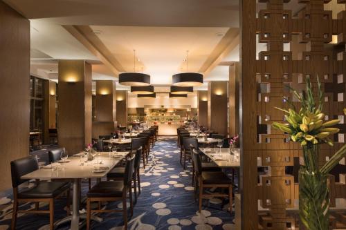 a restaurant with tables and chairs in a room at Sofitel Gold Coast Broadbeach in Gold Coast