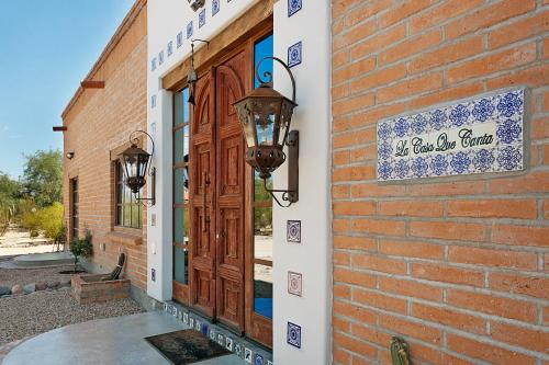 a brick building with a door and a sign on it at La Casa que Canta in Tucson