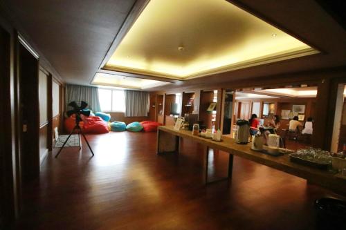 a living room with a long table and a camera at Glur Central Pratunam in Bangkok