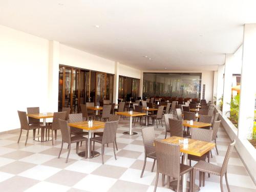 an empty restaurant with tables and chairs at Harmoni Hotel Garut in Garut