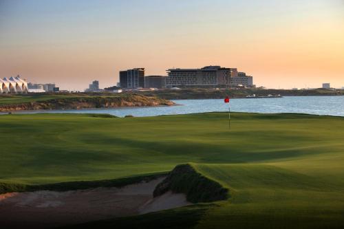 a golf course with a view of the ocean at Park Inn by Radisson Abu Dhabi Yas Island in Abu Dhabi