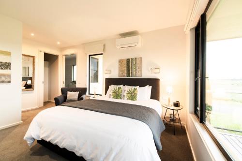 a bedroom with a large bed and a large window at Hilltop Apartments Phillip Island in Cowes