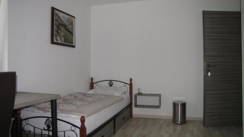 a small bedroom with a bed and a table at Dom Vita Sticna in Ivančna Gorica