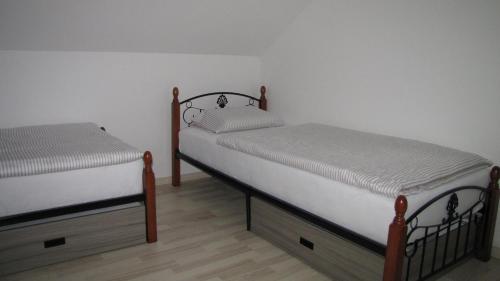 2 łóżka pojedyncze w pokoju z białymi ścianami w obiekcie Dom Vita Sticna w mieście Ivančna Gorica