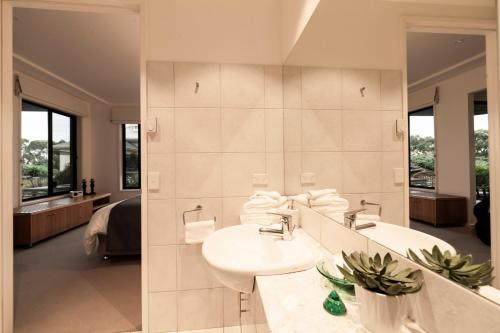 a bathroom with two sinks and a large mirror at Hilltop Apartments Phillip Island in Cowes