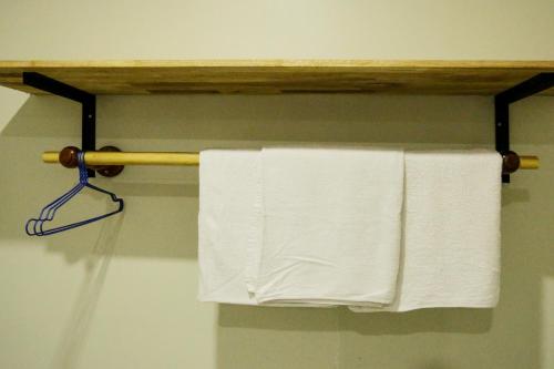 a towel rack with white towels hanging on it at Blue Diamond Hostel in Battambang