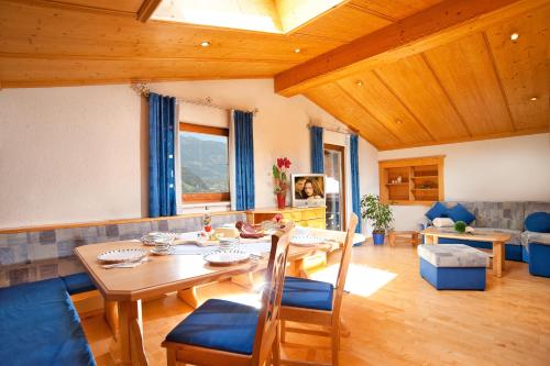 sala de estar con mesa de madera y sillas en Tofererhof, en Bad Hofgastein