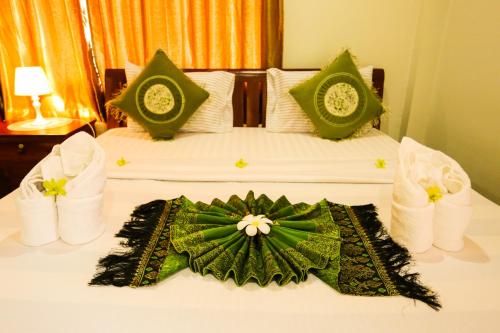 a hotel room with a bed with a flower on it at Blue Diamond Hostel in Battambang