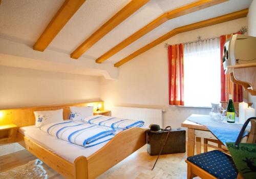 a bedroom with a bed with blue and white sheets at Tofererhof in Bad Hofgastein