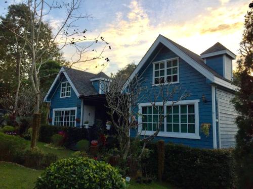 a blue house with a white at Baan JaoKorKluay บ้านเจ้ากอกล้วย in Chiang Rai