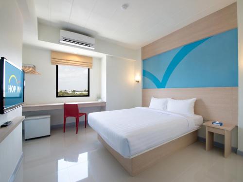 a hotel room with a bed and a television at HOP INN Chiang Mai Superhighway in Chiang Mai