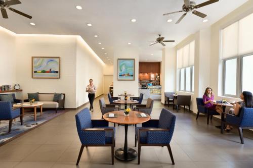 a lobby of a hotel with people sitting at tables at Shangri-La Serviced Apartments, Yangon in Yangon