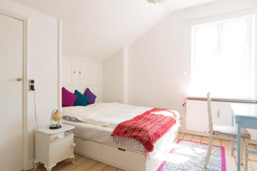 a white bedroom with a bed and a desk at Spacious Private Apartment for Family Holiday in Stege