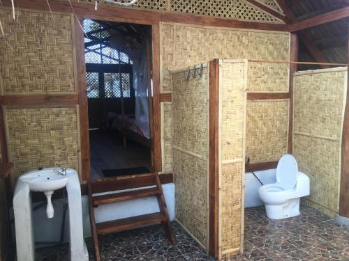 a bathroom with a toilet and a sink at Beach Hut by S.A.R. in Waingapu