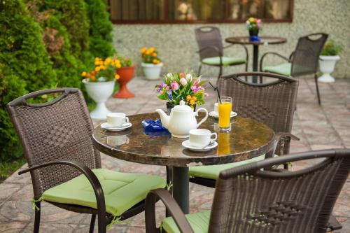 a table and chairs with coffee cups and flowers on it at Discovery Hotel in Bishkek