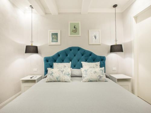 a bedroom with a large bed with a blue headboard at A cà da Alba Rooms in Monterosso al Mare