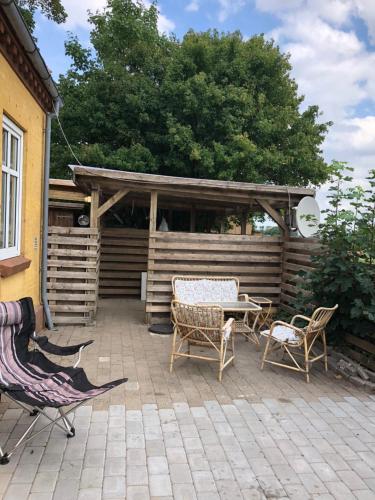 een patio met stoelen, een tafel en een paviljoen bij A Big Holidayhouse Rømø-Rim-Ribe in Skærbæk