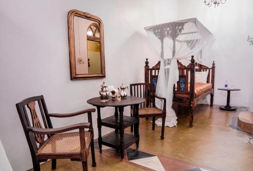 a room with a table and chairs and a mirror at Zanzibar Coffee House in Zanzibar City