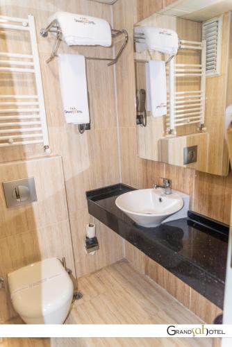 a bathroom with a white toilet and a sink at GRAND ŞAH OTEL in Eskisehir