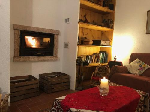 a living room with a fireplace and a candle on a table at Chalet Maso Pino in Castello Tesino
