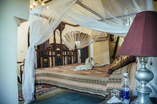a bedroom with a bed with a canopy at Zanzibar Coffee House in Zanzibar City