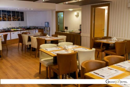 a restaurant with tables and chairs and a kitchen at GRAND ŞAH OTEL in Eskisehir