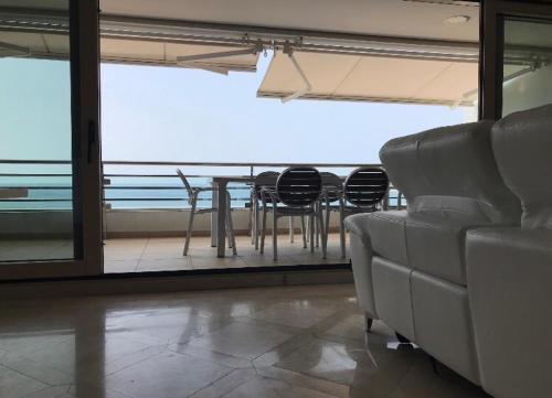 un soggiorno con divano, tavolo e sedie di Praia da California Apartment a Sesimbra