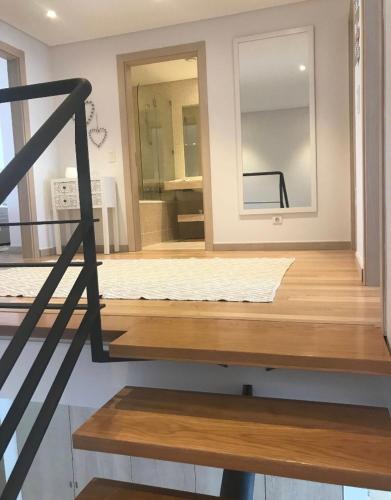 a room with a mirror and a wooden floor at Praia da California Apartment in Sesimbra