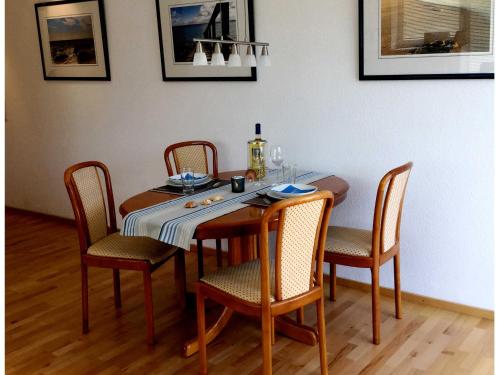 mesa de comedor con sillas, mesa y sillón en Ostseeresidenz App 2, en Pelzerhaken