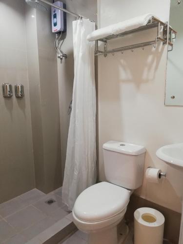 ein Badezimmer mit Toilette, Dusche und Waschbecken in der Unterkunft Eon Centennial Express Hotel in Iloilo City