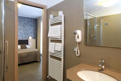 une salle de bain avec un lavabo, un miroir et un lit dans l'établissement Villa Gioiosa, à Diano Marina