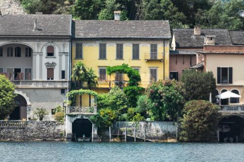 una casa amarilla en la orilla del agua en La Casa dell'Isola en Orta San Giulio