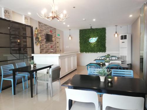 a dining room with a black table and chairs at Eon Centennial Express Hotel in Iloilo City