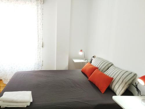 a bedroom with a large black bed with orange pillows at As Casiñas in Ribadavia